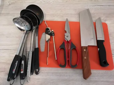 a group of knives and other kitchen utensils on a cutting board at W36 WarmStay atGoldenHills NightMarket 4R Wifi BBQ in Brinchang