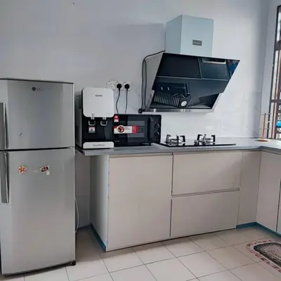 a kitchen with white cabinets and a refrigerator at Homestay De' Humaira - USM Nibong Tebal in Nibung Tebal