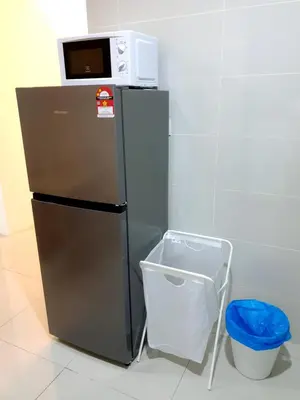 a microwave on top of a refrigerator with a trash can at ●SSV10●4pax●Comfort House●13minit●Airpot●CondoPool in Bayan Lepas