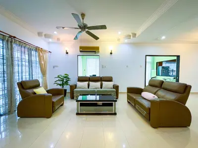 a living room with couches and a ceiling fan at Tupai Mas Semi-D 4BR 2mins to LakeGarden & Zoo in Taiping
