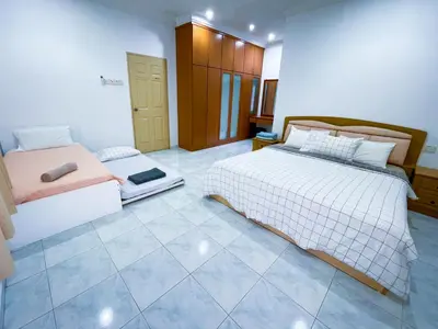 a bedroom with two beds and a tiled floor at Tupai Mas Semi-D 4BR 2mins to LakeGarden & Zoo in Taiping