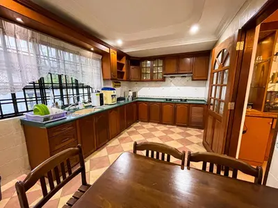 a kitchen with a wooden table and chairs and a sink at Tupai Mas Semi-D 4BR 2mins to LakeGarden & Zoo in Taiping