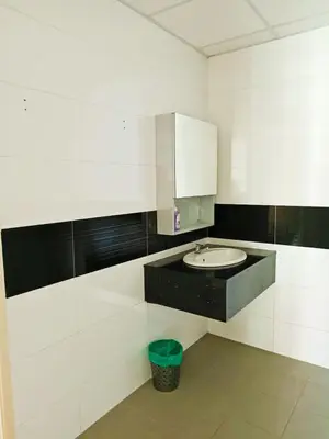 a bathroom with a sink and a trash can at Mansion One Two Bedroom Seaview 7 Pax in George Town