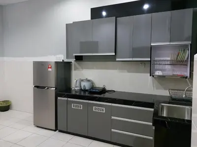 a kitchen with stainless steel appliances and gray cabinets at Pelangi homestay in Kampung Bota Kiri