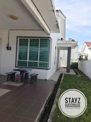 a house with a patio with a table in front of it at Stayz Guesthouse in Sungkai