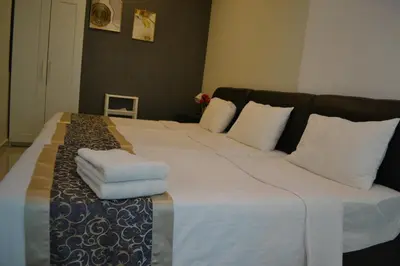 a large bed with white sheets and pillows on it at MARITIME SUITE DUPLEX PENANG- PEMANDANGAN LAUT in George Town