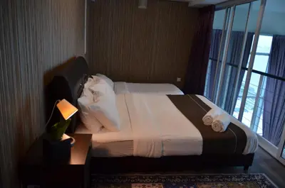 a bed in a hotel room with a large window at MARITIME SUITE DUPLEX PENANG- PEMANDANGAN LAUT in George Town