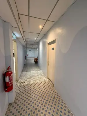a hallway with a tile floor and a fire extinguisher at HOTEL MIRAMA \u7f8e\u9e97\u83ef\u9152\u5e97 in Sitiawan