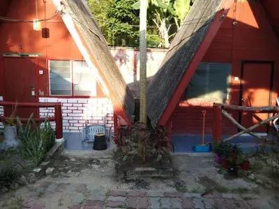 a house with a gambrel roof on the front of it at Nazri Nipah Camp Pangkor in Kampung Teluk Nipah