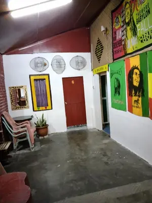 a room with posters on the walls and a red door at Nazri Nipah Camp Pangkor in Kampung Teluk Nipah