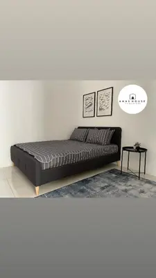 a black bed in a room with a white wall at Anas House in Tanjung Rambutan