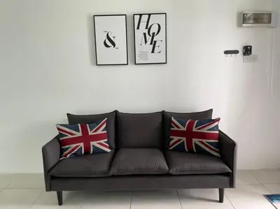 a black couch with british flag pillows on it at Anas House in Tanjung Rambutan