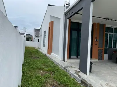 a row of white houses with a car parked outside at Anas House in Tanjung Rambutan