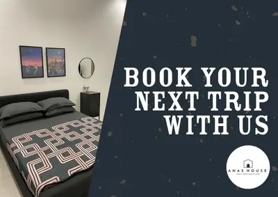 a bedroom with a bed and a sign that reads book your next trip with us at Anas House in Tanjung Rambutan