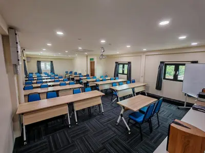 a classroom with desks and blue chairs in it at Pangkor Pop Ash Hotel in Pangkor