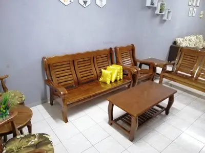 a living room with a wooden bench and chairs at HOMESTAY PERPADUAN, TAMAN BERCHAM RAYA ULU KINTA IPOH PERAK in Kampong Batu Lapan