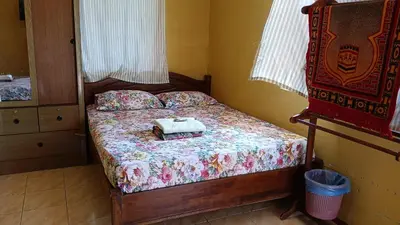 a small bedroom with a bed with a pillow on it at KAMILA MOTEL TELUK SENANGIN in Lumut