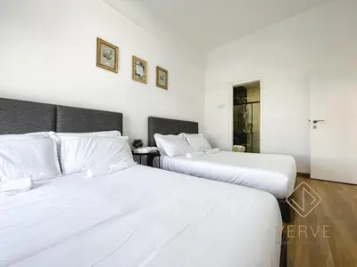 two beds in a hotel room with white sheets at Ipoh Cove Premium Suites by Verve in Ipoh