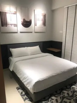 a bed in a bedroom with pictures on the wall at New Ipoh The Majestic Condo Homestay in Ipoh