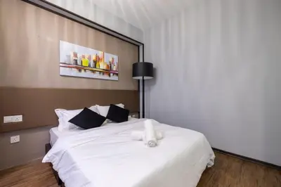 a bedroom with a white bed with a stuffed animal on it at Loft Pano Seaview Suite 2 Bedroom by The Only Bnb in Jelutong