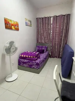 a room with a purple bed and a fan at Cameron Lavender Homestay 3 in Tanah Rata