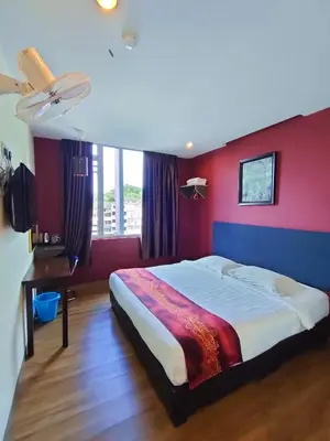 a bedroom with a large bed with a red wall at HOTEL YTS in Brinchang