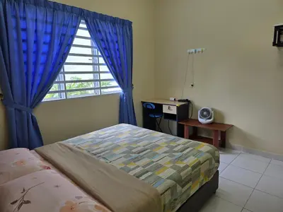 a bedroom with a bed and a window with blue curtains at The Simplicity Homestay in Tanah Rata