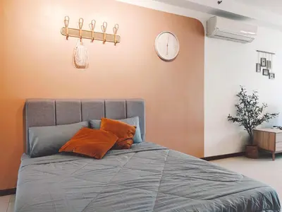 a bedroom with a bed with orange pillows and a clock at THE LANDMARK BY KATANA New 3BR Grand Seaview Homestay at Gurney \u65e0\u654c\u6d77\u666f\u4e09\u623f\u5957\u623f in Tanjung Bungah