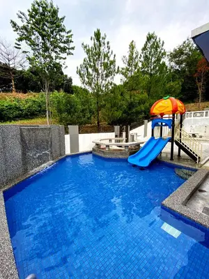 a blue swimming pool with a slide and an umbrella at 50PAX 9BR Villa Kids Swimming Pool, KTV, BBQ n Pool Tables near SPICE Arena Penang 9800 SQFT in Bayan Lepas