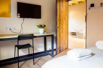 a room with a desk with a chair and a television at Explore 5BR Gardenhouse Retreats (Free Parking) in Butterworth