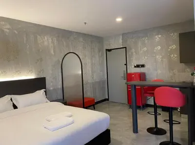a bedroom with a bed and a table and chairs at Sri Indar Hotel & Suites in Parit Buntar
