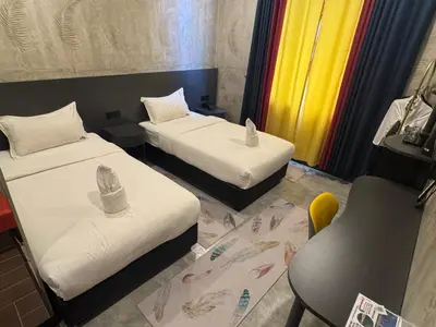 a hotel room with two beds and a chair at Sri Indar Hotel & Suites in Parit Buntar