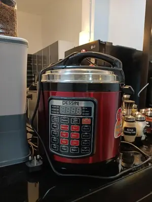 a red slow cooker sitting on top of a counter at HOMESTAY SYAABAN Kamunting Taiping Batu Kurau Ulu Sepetang in Kamunting