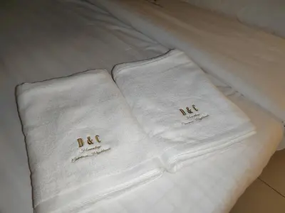 two towels sitting on top of a bed at D&C Homestay A Modern Forest Boutique in Brinchang