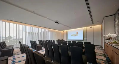 a conference room with chairs and a screen at Amari SPICE Penang in Bayan Lepas
