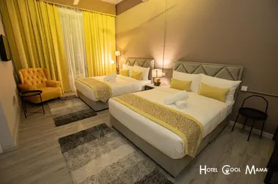 a hotel room with two beds and a chair at Hotel COOL MAMA in Brinchang