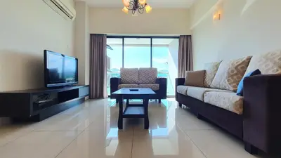 a living room with a couch and a tv and a table at Kinta River Front Suites Ipoh by Beestay in Ipoh