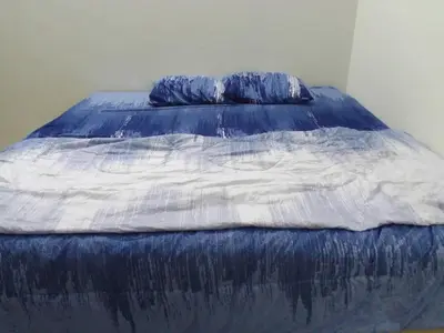 a blue and white bed with two pillows on it at HOMESTAY IMPIAN, BATU GAJAH PERAK in Kampong Paya Rengas