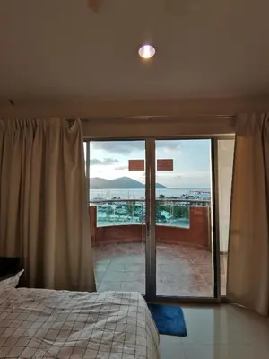 a bedroom with a bed and a sliding glass door at Spacious & Homey Apartment at Marina Island by JoMy Homestay in Lumut