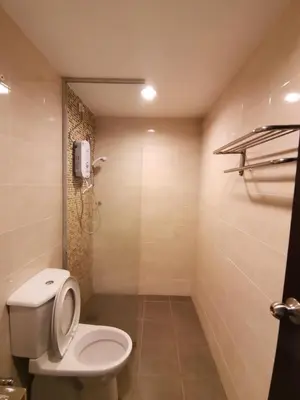 a bathroom with a toilet and a phone on the wall at Spacious & Homey Apartment at Marina Island by JoMy Homestay in Lumut