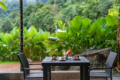 a black table with two chairs and a table with food on it at TUI BLUE The Haven Ipoh in Ipoh