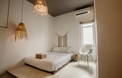 a bedroom with a bed and a chair and chandelier at Amazing Home Inn in George Town