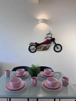 a table with plates and a scooter on the wall at EE's Summer House - Homestay 3 min walk to beach in Batu Ferringhi