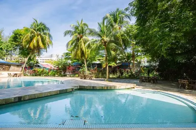 a swimming pool in a resort with palm trees at EE's Summer House - Homestay 3 min walk to beach in Batu Ferringhi