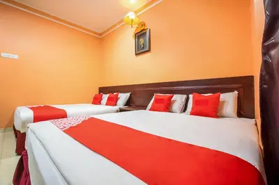 two beds in a room with red and white at Ipoh Times Inn Hotel in Ipoh