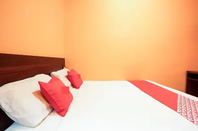 a bedroom with a bed with red and white pillows at Ipoh Times Inn Hotel in Ipoh