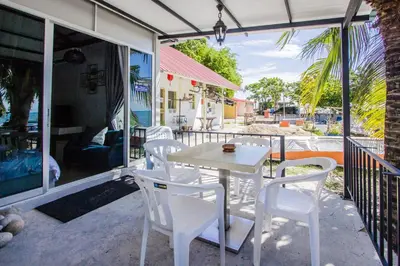 a white table and chairs on a patio at Beachboy Chalet By The Beach in Bukit Lada