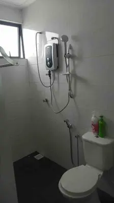 a small bathroom with a toilet and a shower at Lizs Homestay in Ipoh