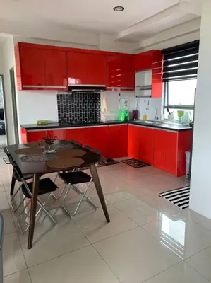 a kitchen with red cabinets and a wooden table at Lizs Homestay in Ipoh