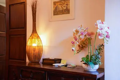 a table with a vase and flowers on it at East Indies Mansion in George Town